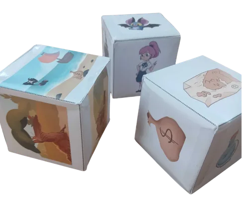 Three illustrated paper cubes, story starters, with drawings of animals and Junior Éditions comic characters.